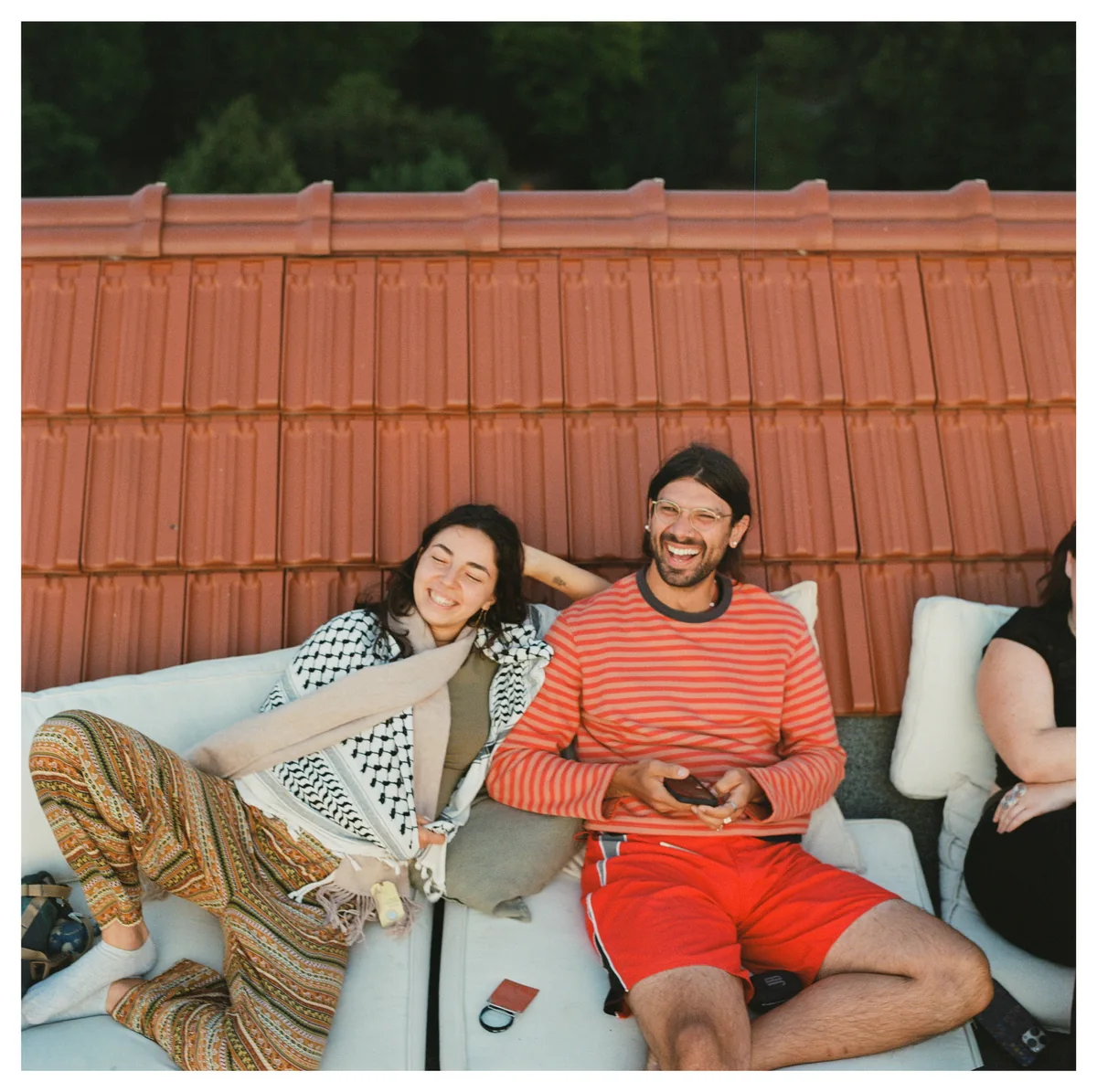 Karam and a friend laughing together on a rooftop